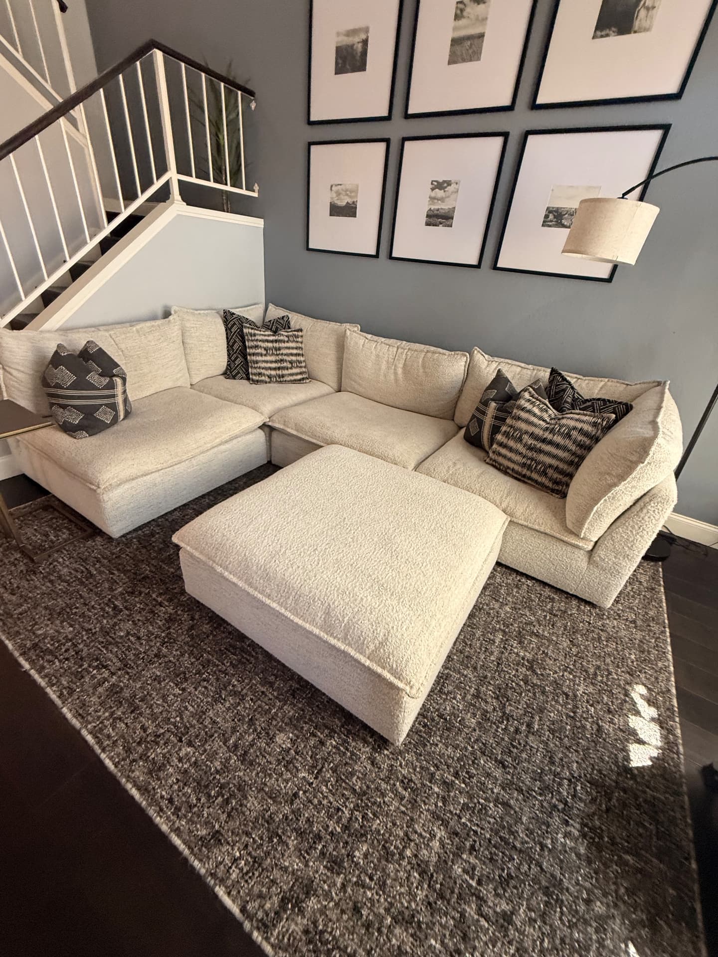 Freshly cleaned living room with sectional, rug and gallery wall after a Lustre Haus standard clean in Scottsdale