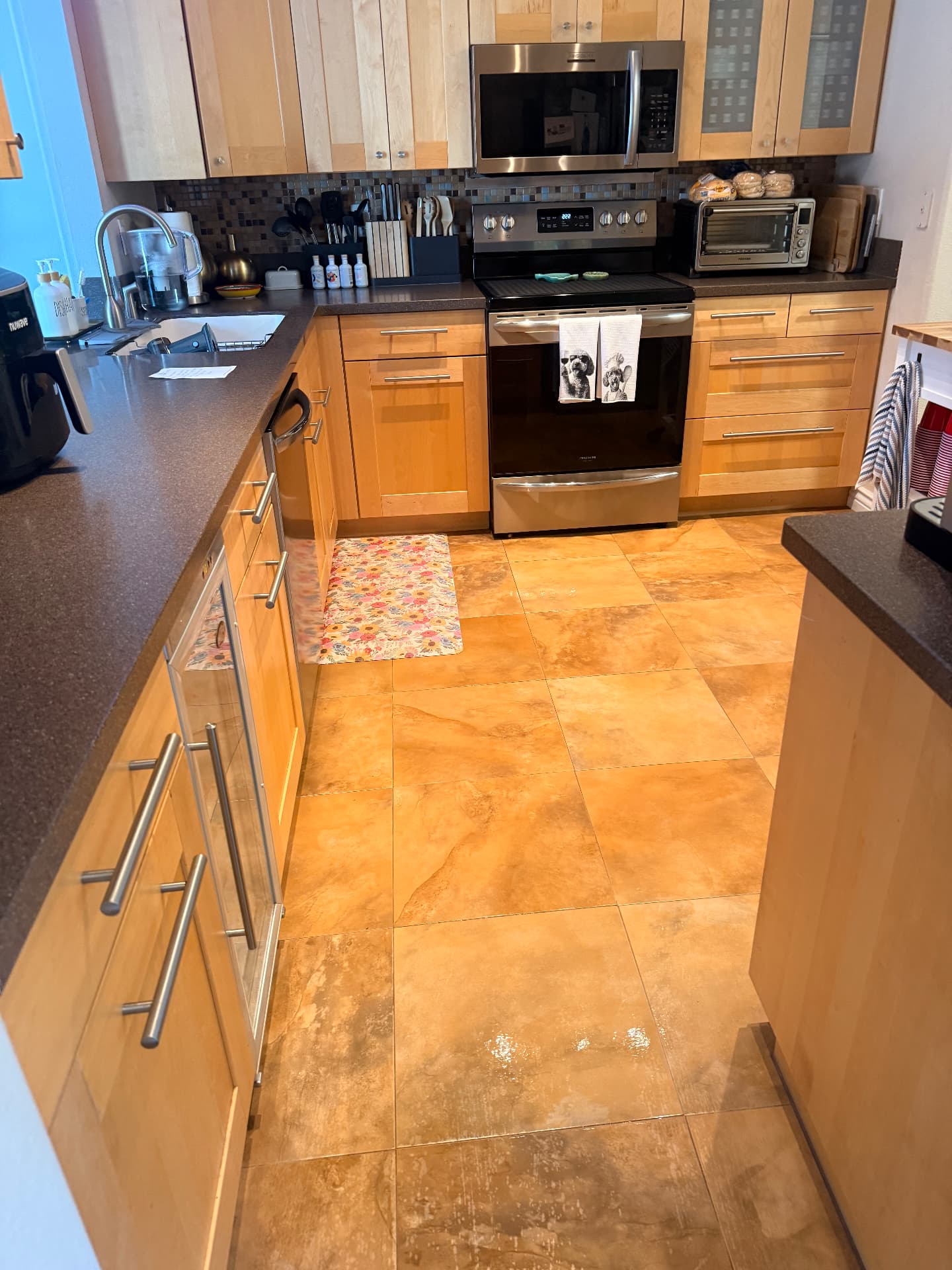 Kitchen with polished countertops, stovetop and mopped tile floor after a Lustre Haus deep clean in Phoenix